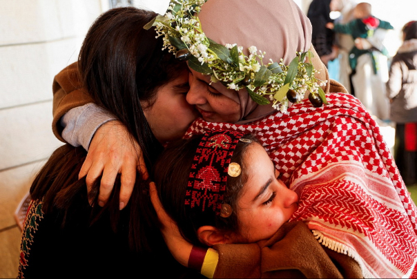 اسیر زن فلسطینی پس از آزادی از زندان های اسرائیل ، کودکان خود را در آغوش می گیرد