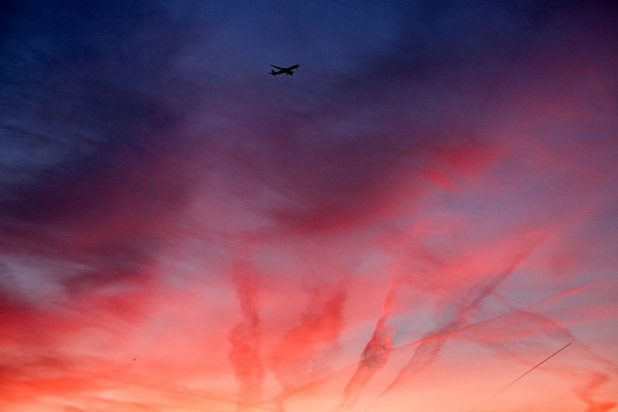 پرواز هواپیما بر فراز شهر هنگام طلوع آفتاب،فرانکفورت، آلمان