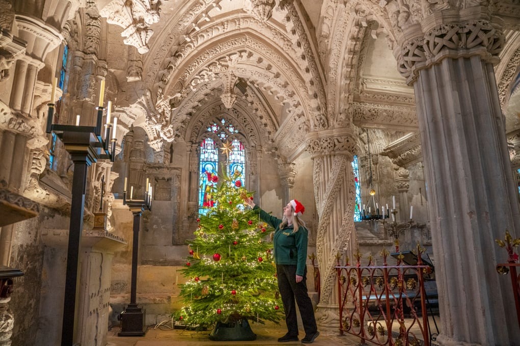 راهنمای کلیسا، در حال انجام آخرین مراحل تزیین درخت کریسمس در کلیسای پر زرق و برق راسلین در اسکاتلند است